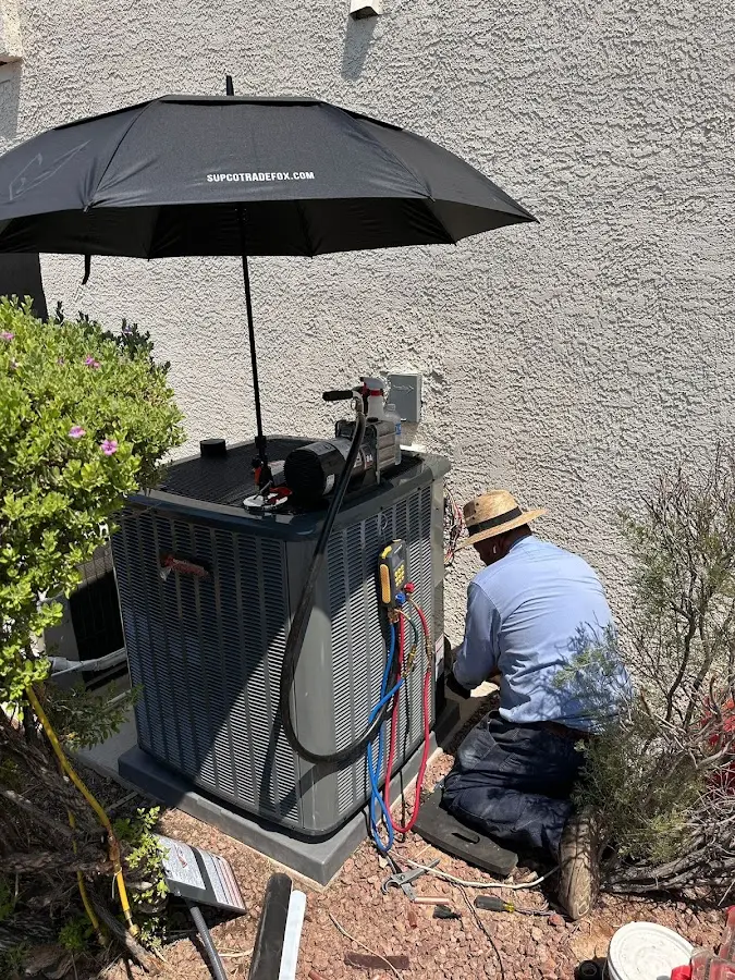 HVAC technician performing outdoor AC maintenance in Center Line